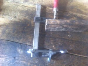 il suffit de placer l'extrémité de la clé sous la coupelle de ressort , la queue de soupape étant passé dans le centre de la coupelle, le haut du serre-joint sur le plan dejoint et la tête de soupape ( la cale de bois c'est pour protéger le tout ) et on sert et le ressort remonte...